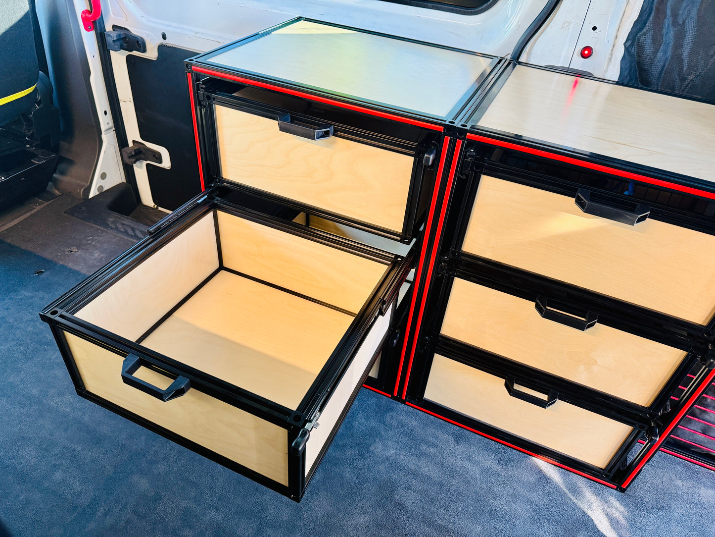 camper van drawers with red trim and one drawer open