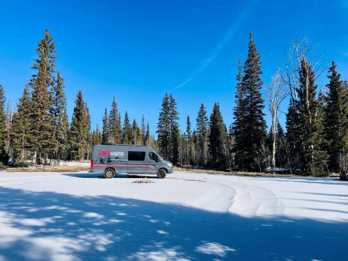 camper van camping in snow on mountain