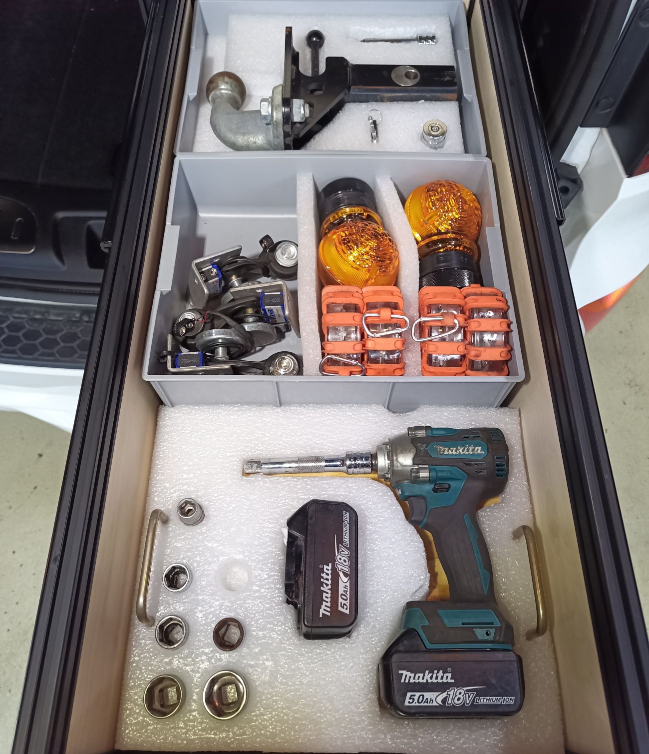 Tool kit with tools and equipment inside a suv cargo drawer