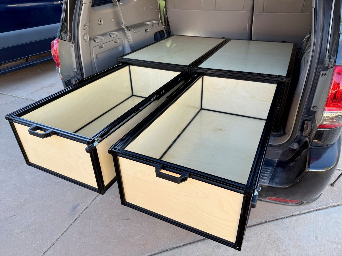 Two large open storage boxes in front of a car